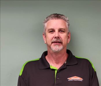 SERVPRO employee in front of gray wall