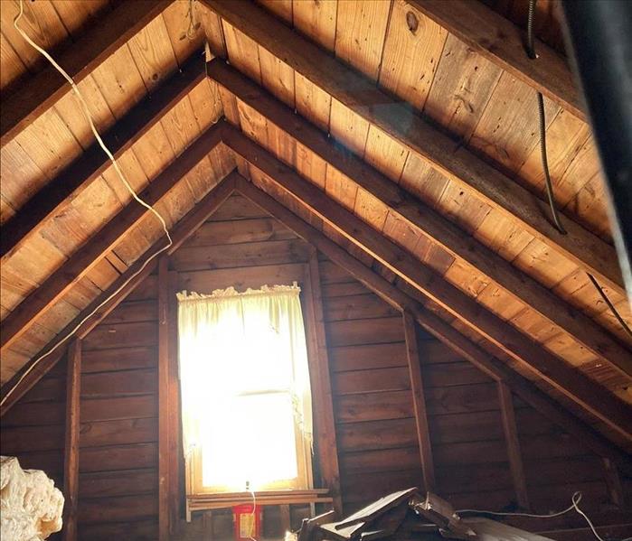 Bare wood ceiling with a large window shinning in.