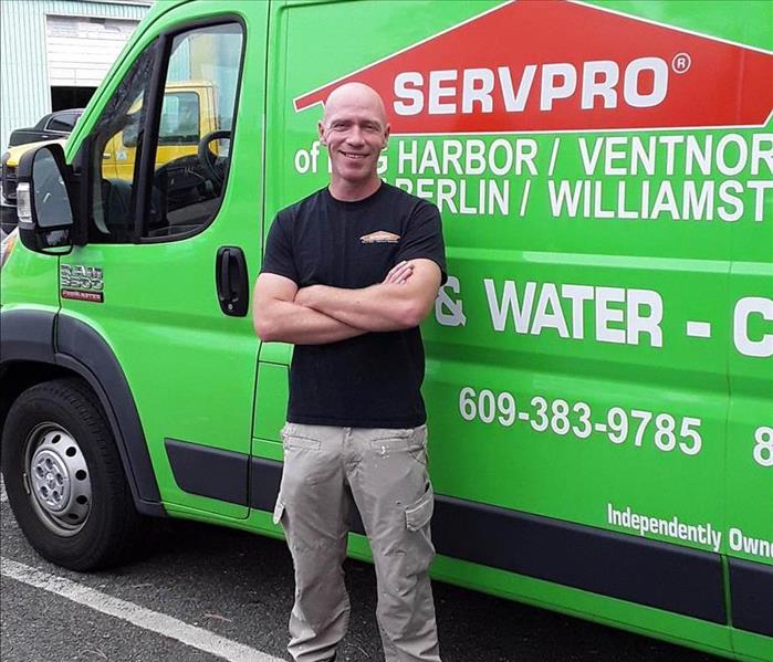 One man standing in front of a SERVPRO green vehicle. 