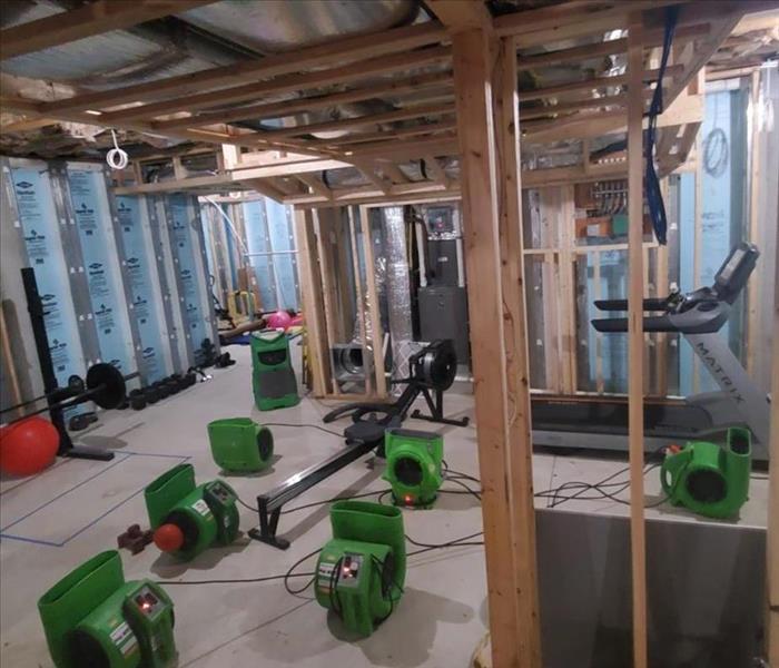 Green air movers on the ground in a garage. 