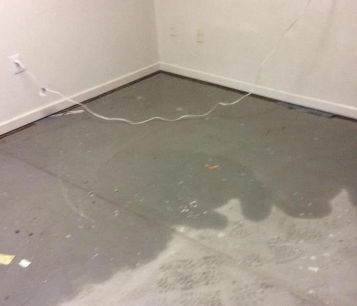 Concrete floor with a dark water stain. 