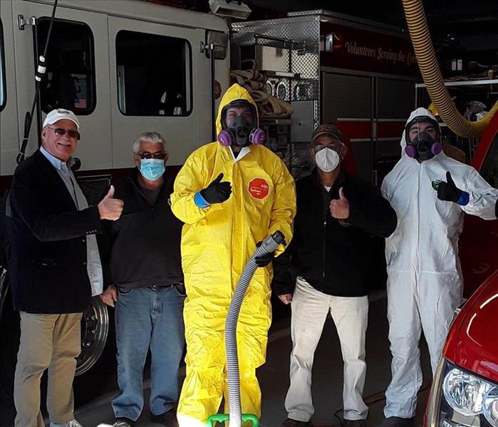 Firefighters and a man in PPE gear. 