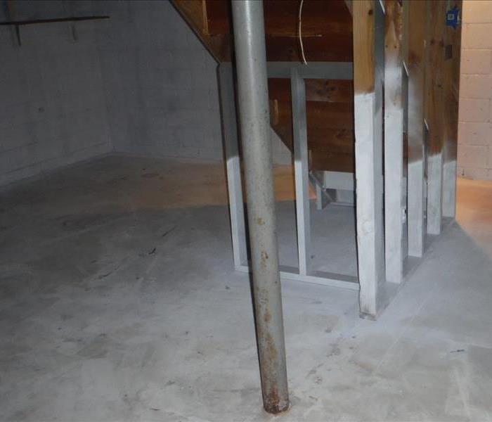 Basement with concrete floors and a metal pole. 
